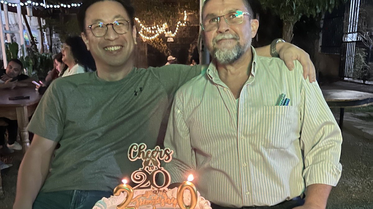 セルヒオ・オルテツさんとミルトンのオーナー。「20」のろうそくを立てたお祝いのケーキを前に
